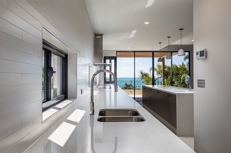 A Kitchen With a Sink and a Window Overlooking the Ocean — Red Emperor Constructions in Cannonvale, QLD