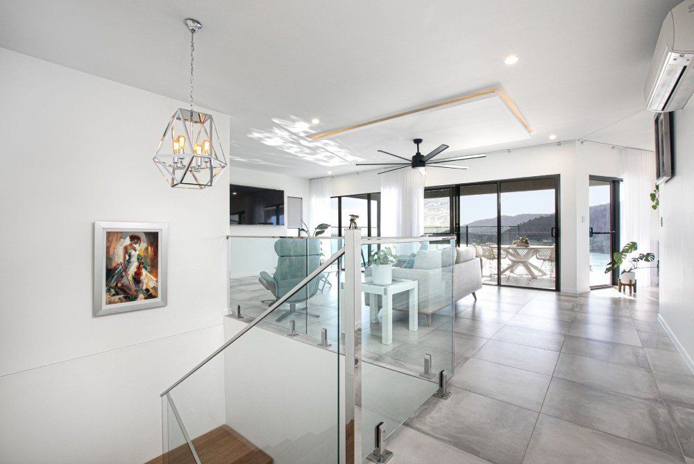 A Living Room With a Staircase Leading Up to the Second Floor — Red Emperor Constructions in Cannonvale, QLD