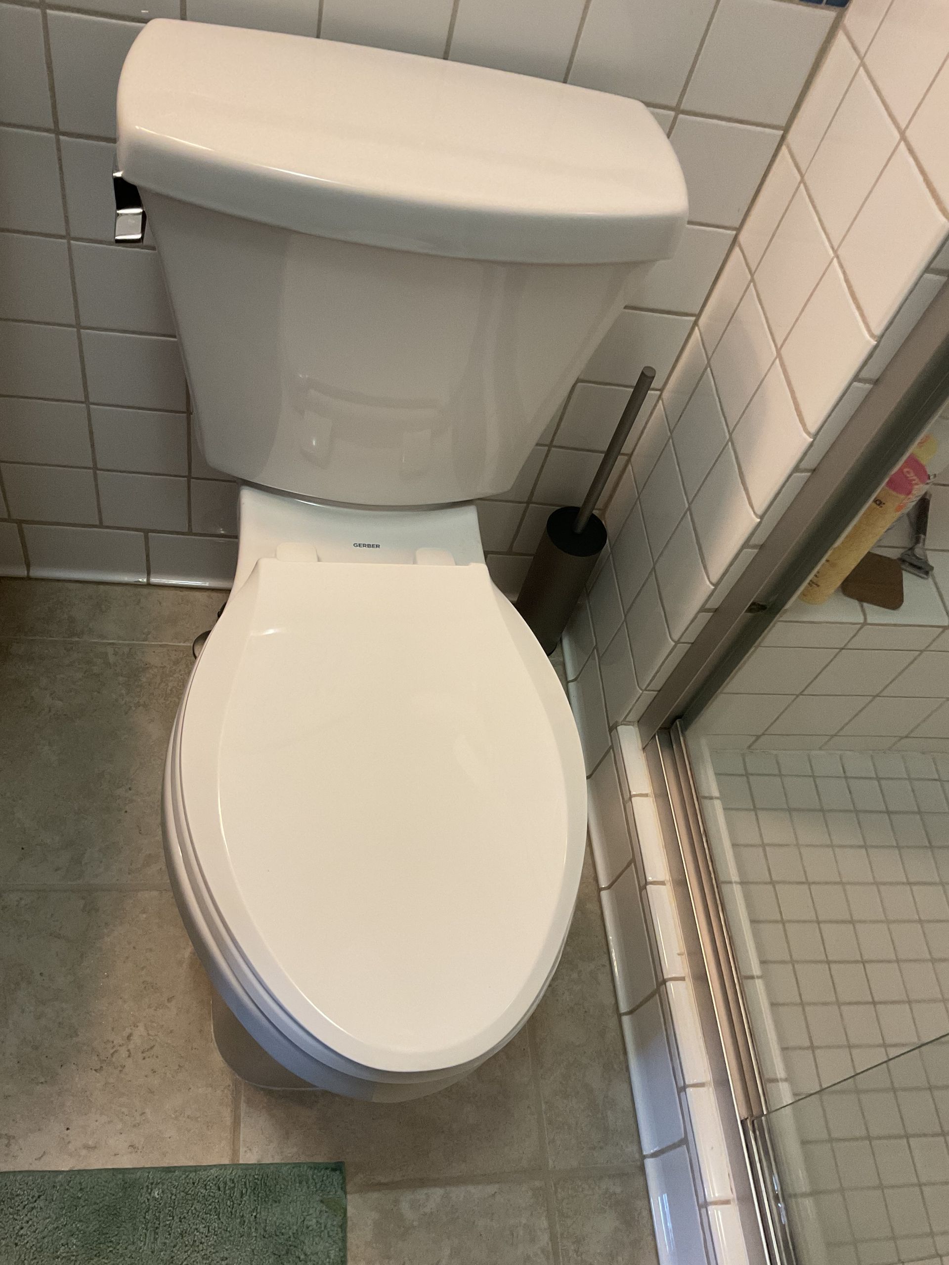 Damaged toilet in a bathroom, with broken seat, loose parts, and debris on the floor.