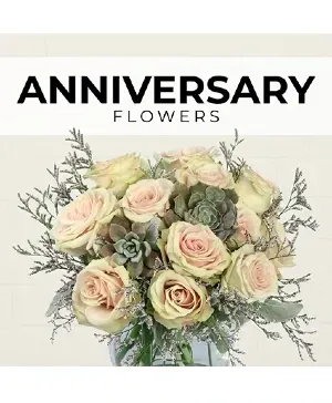 Anniversary flowers in a glass vase. Roses and succulents in a light, neutral color palette.