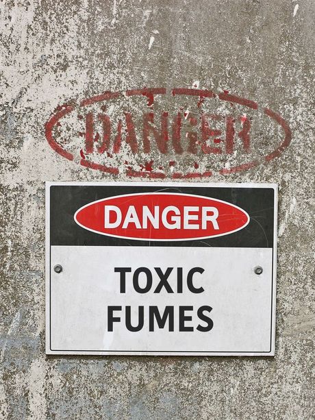 A sign on a wall that says danger toxic fumes