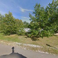 A shadow of a person is cast on the side of a road.