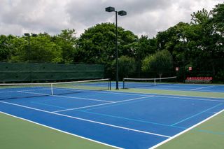 Cross court view of pickleball tennis courts painted blue and green 
