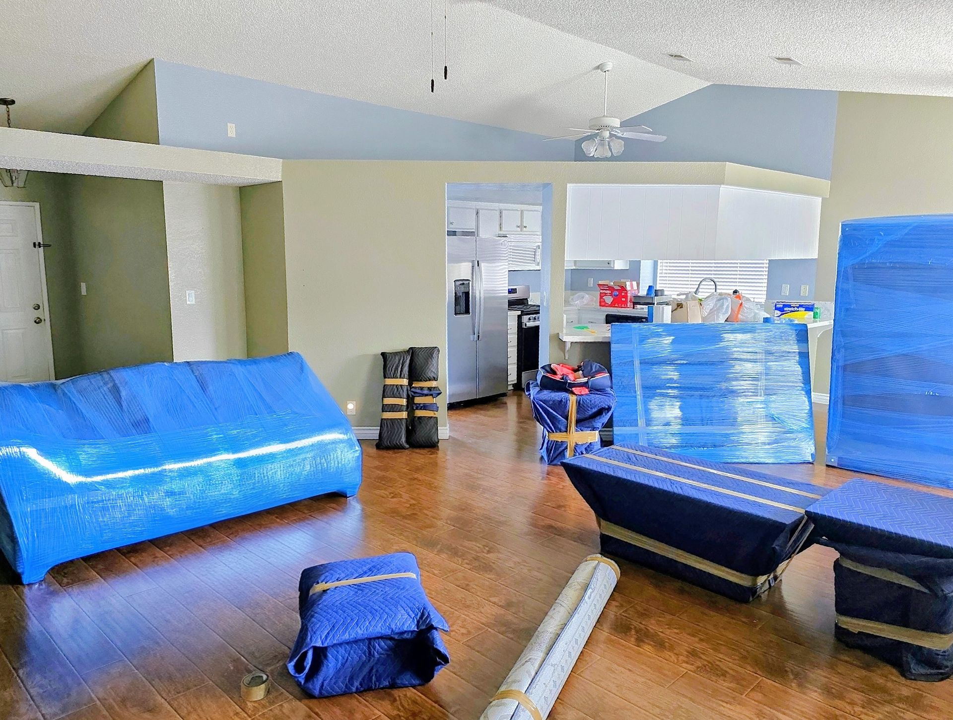 A man is stacking boxes on top of each other in a living room.
