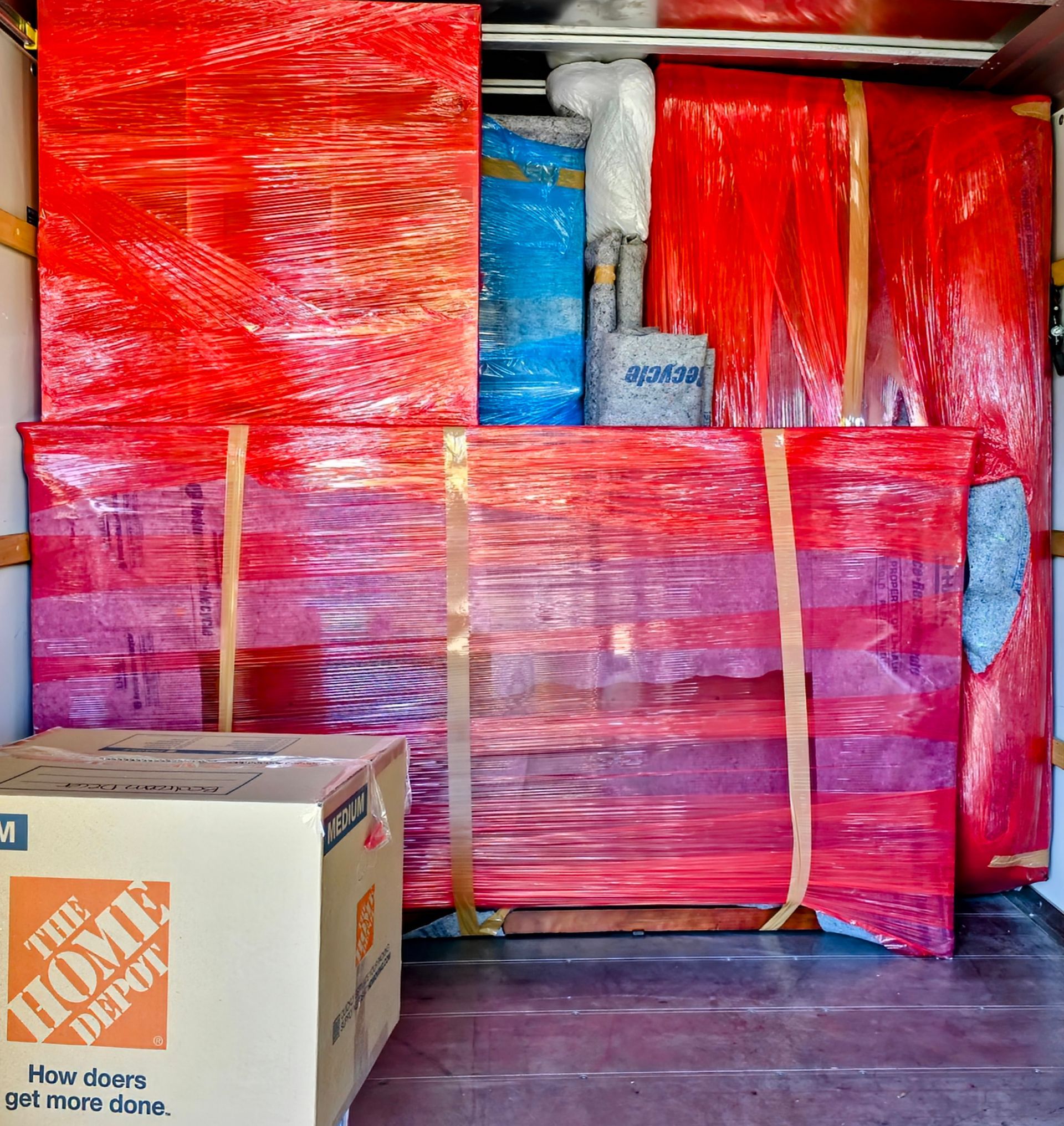 Two men are moving a couch in a living room.