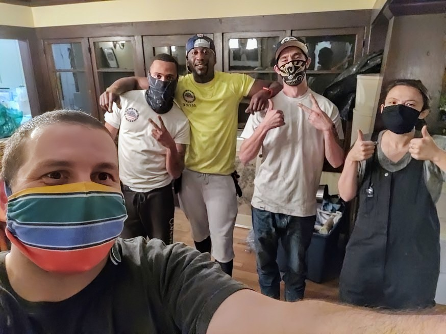 A group of people wearing face masks are posing for a picture.