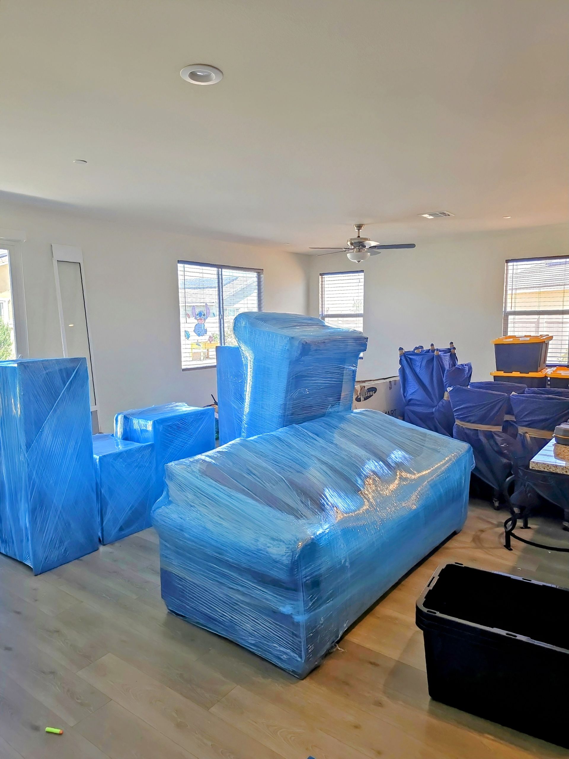 A box is wrapped in plastic wrap and taped to the floor.