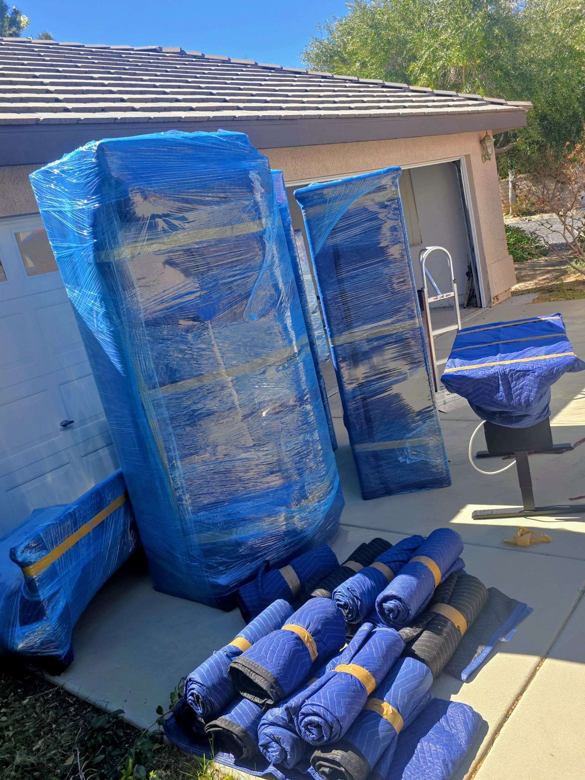 Delivery person loading boxes into a van, standing outside a building.
