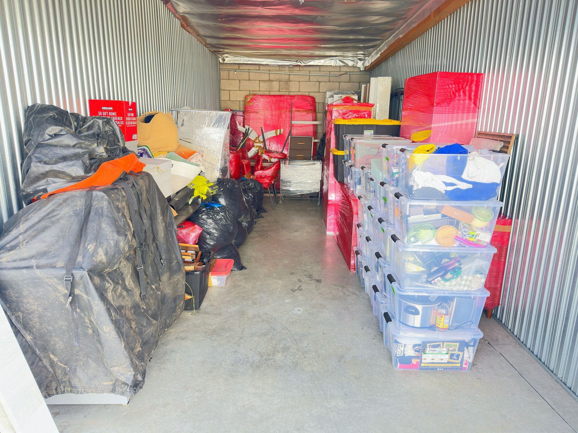 A man is pushing a cart full of boxes that say u-haul
