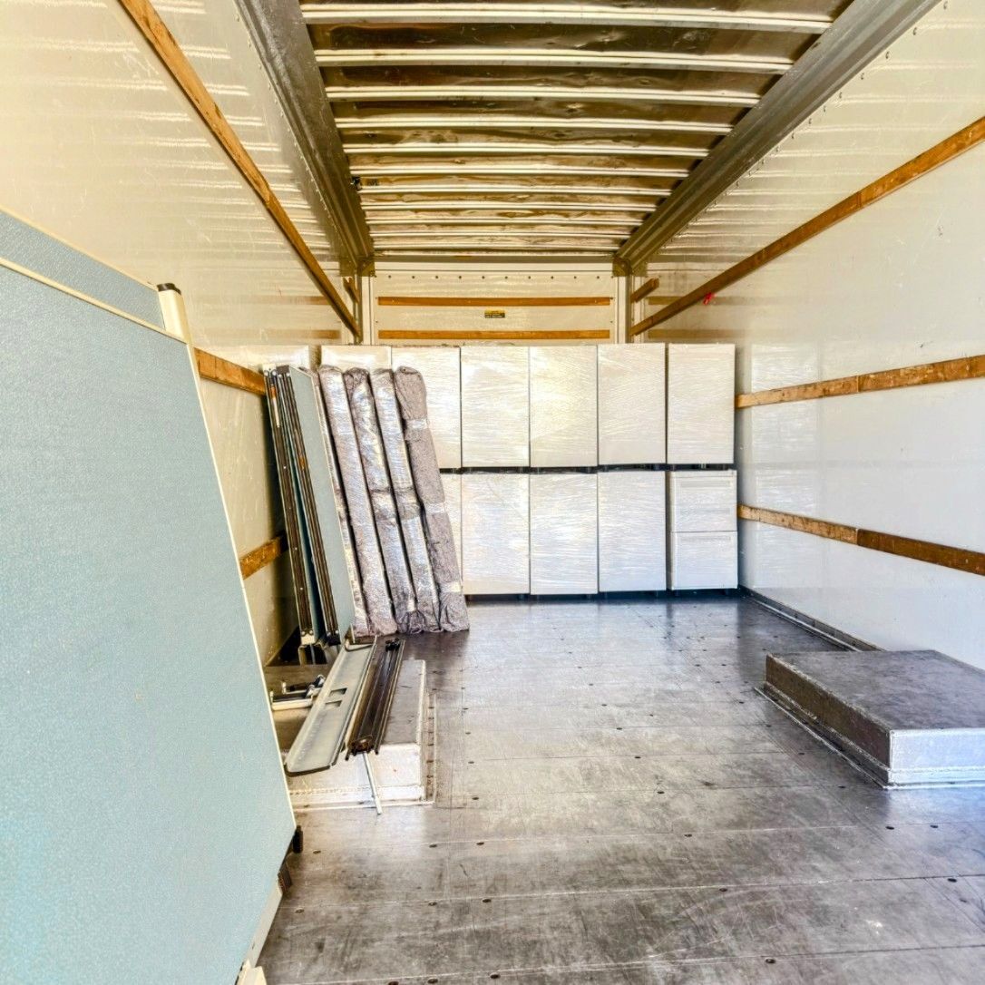 A row of office chairs and boxes in an office with a brick wall.