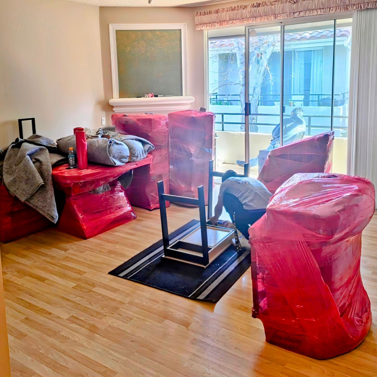 A box is wrapped in plastic wrap and taped to the floor.