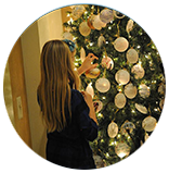 a woman is decorating a christmas tree in a circle .