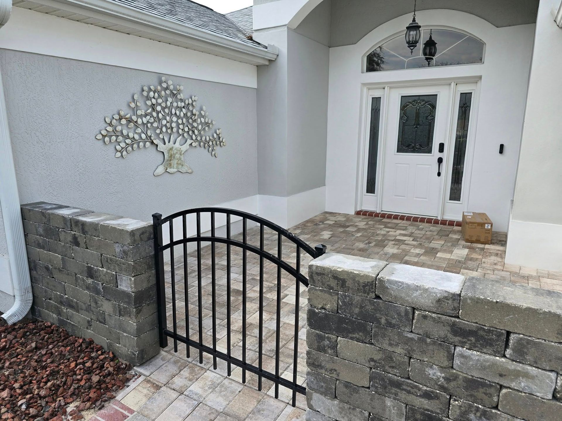 A black gate is in front of a white house.