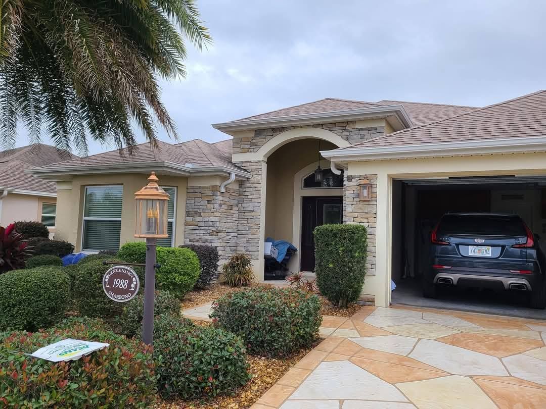 A car is parked in a garage in front of a house.