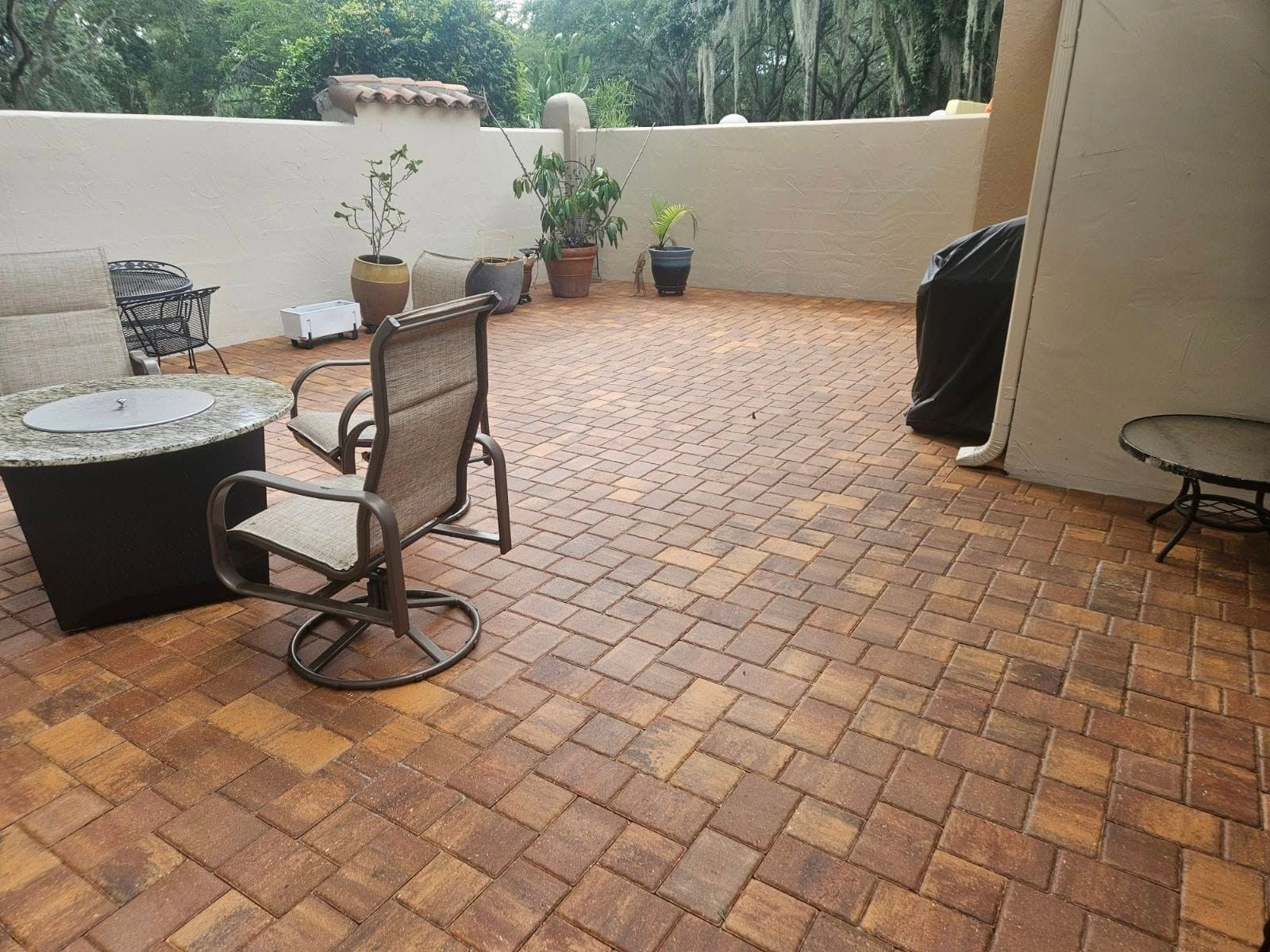 A patio with a fire pit , chairs , and a table.