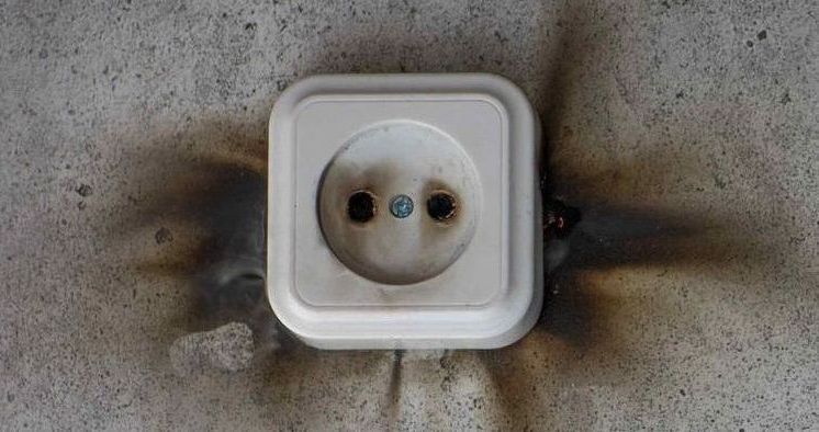 old burnt outlet with black area on wall around it