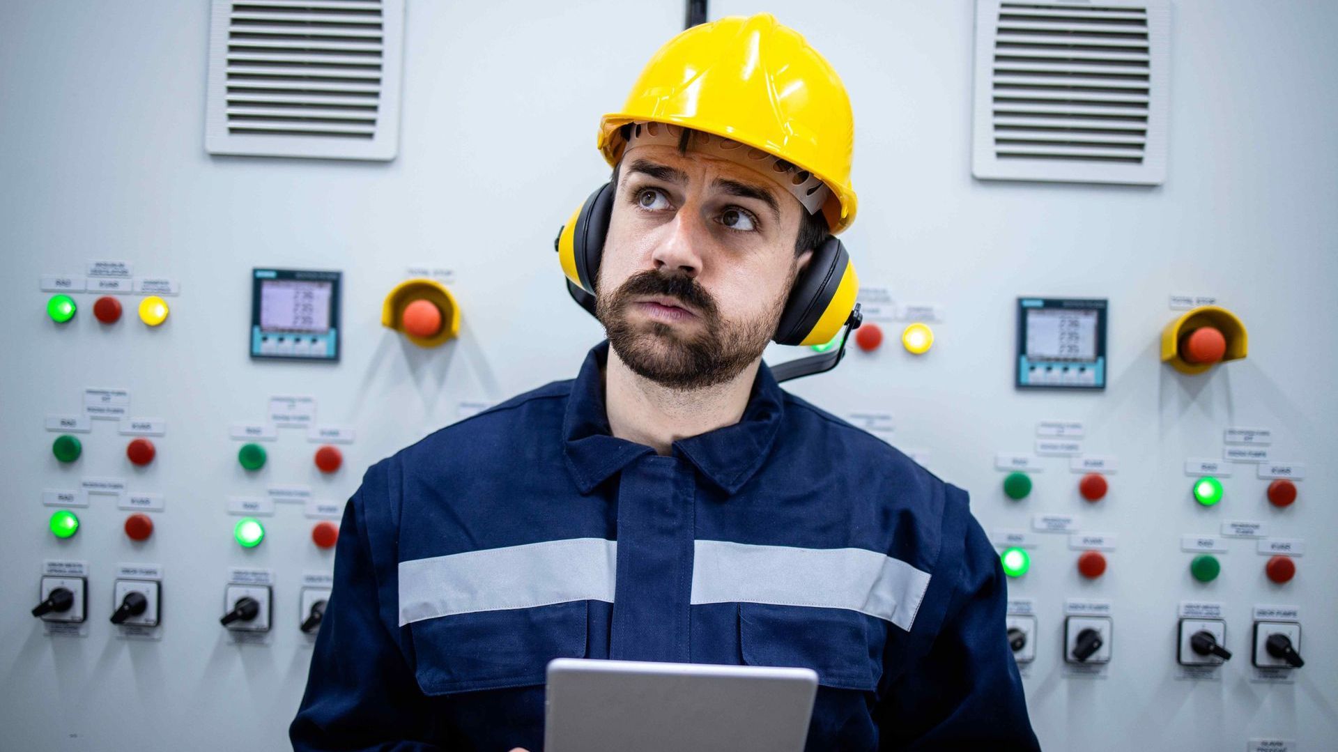 electrician with a puzzled look on his face standing in front of a generator