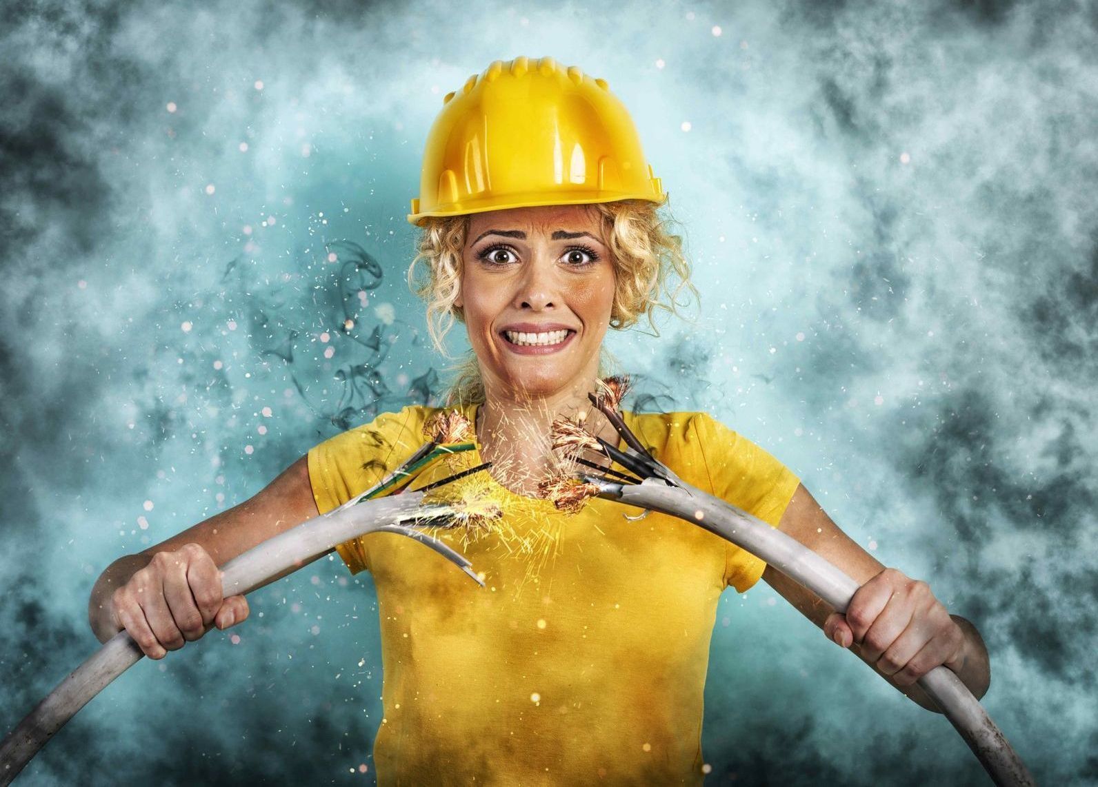 electrician holding 2 frayed sparking wires looking dangerous