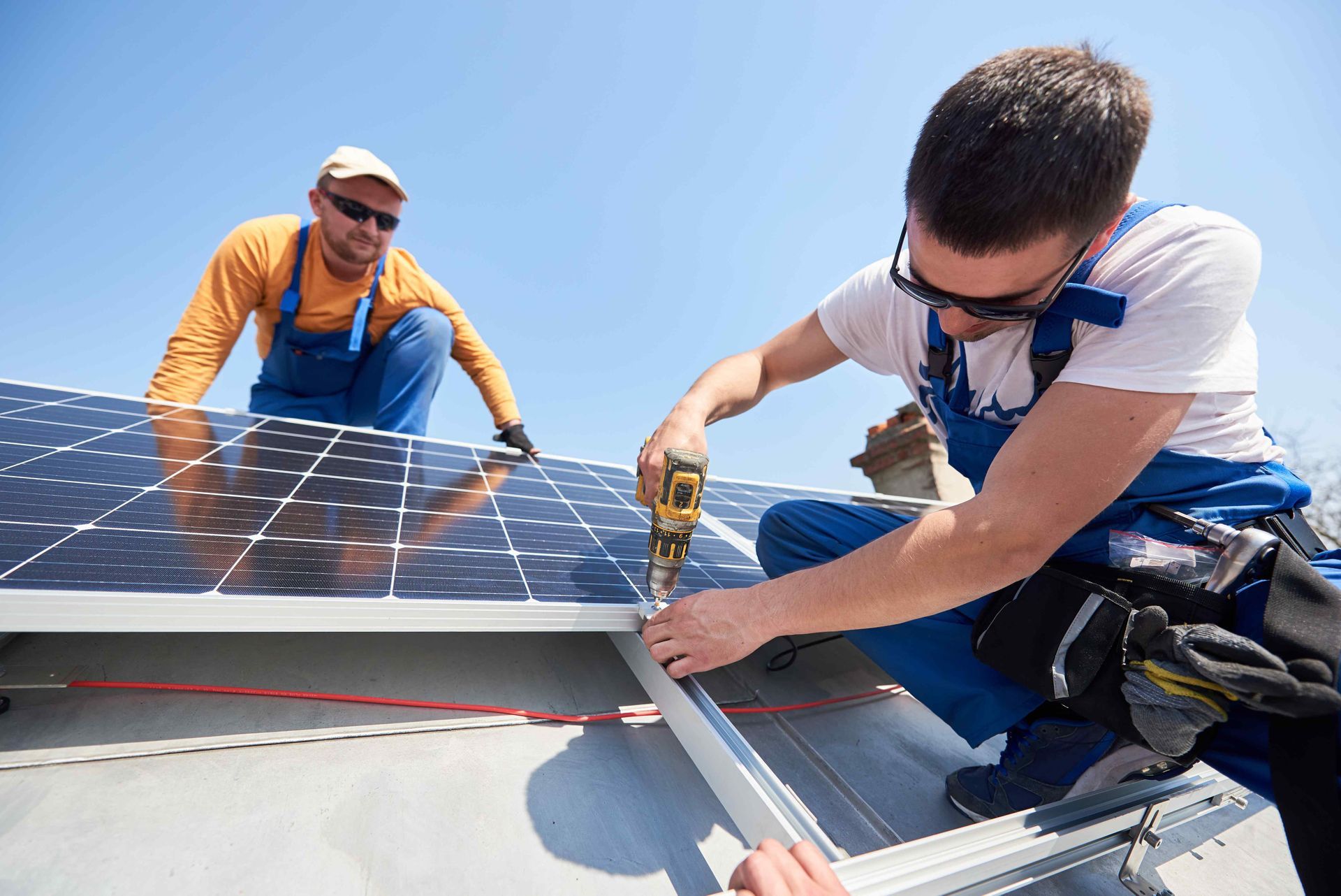 2 electrical contractors installing a series of solar panels