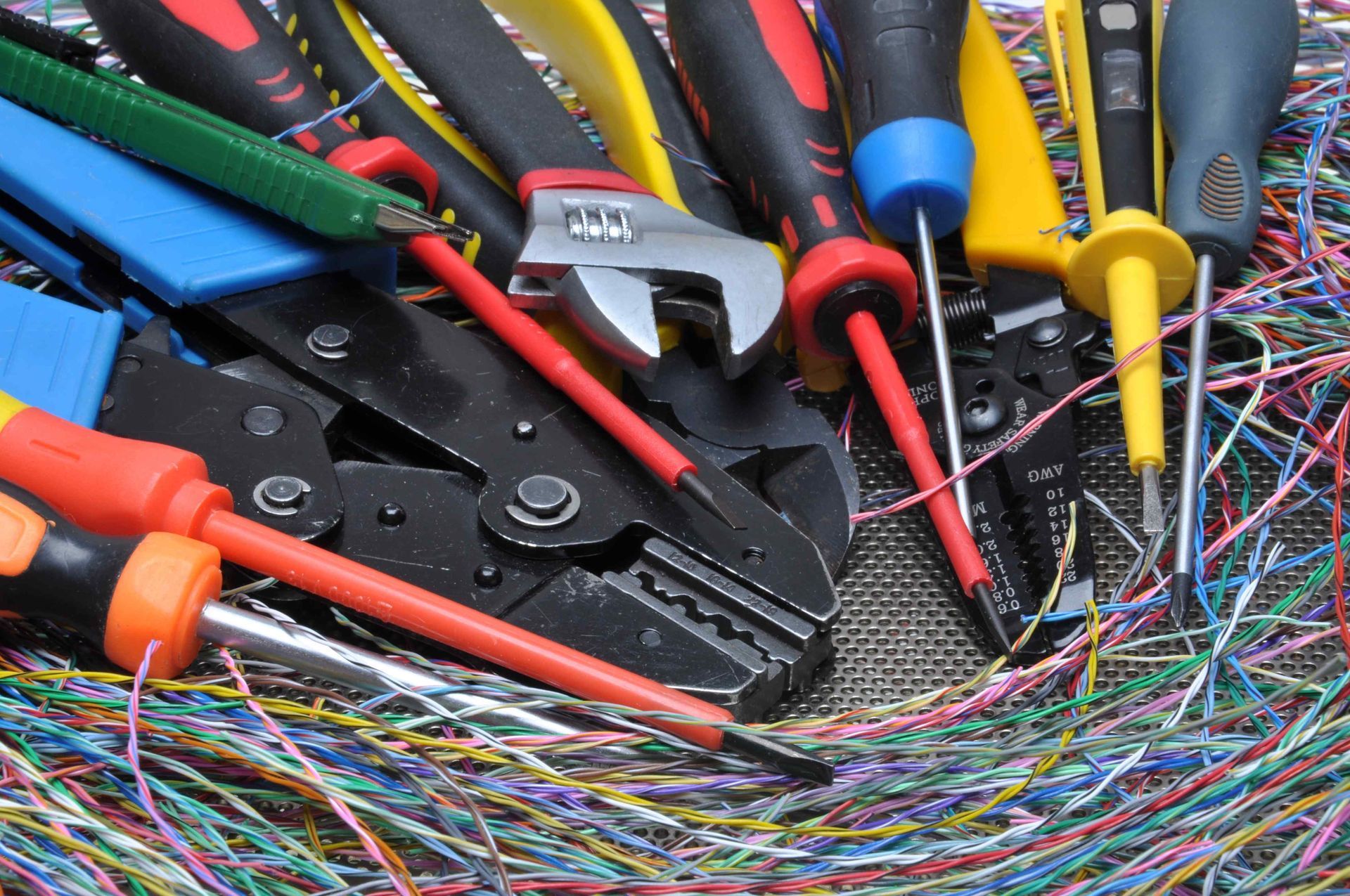 wire cutters, screwdrivers,  and multicolored wires on a table