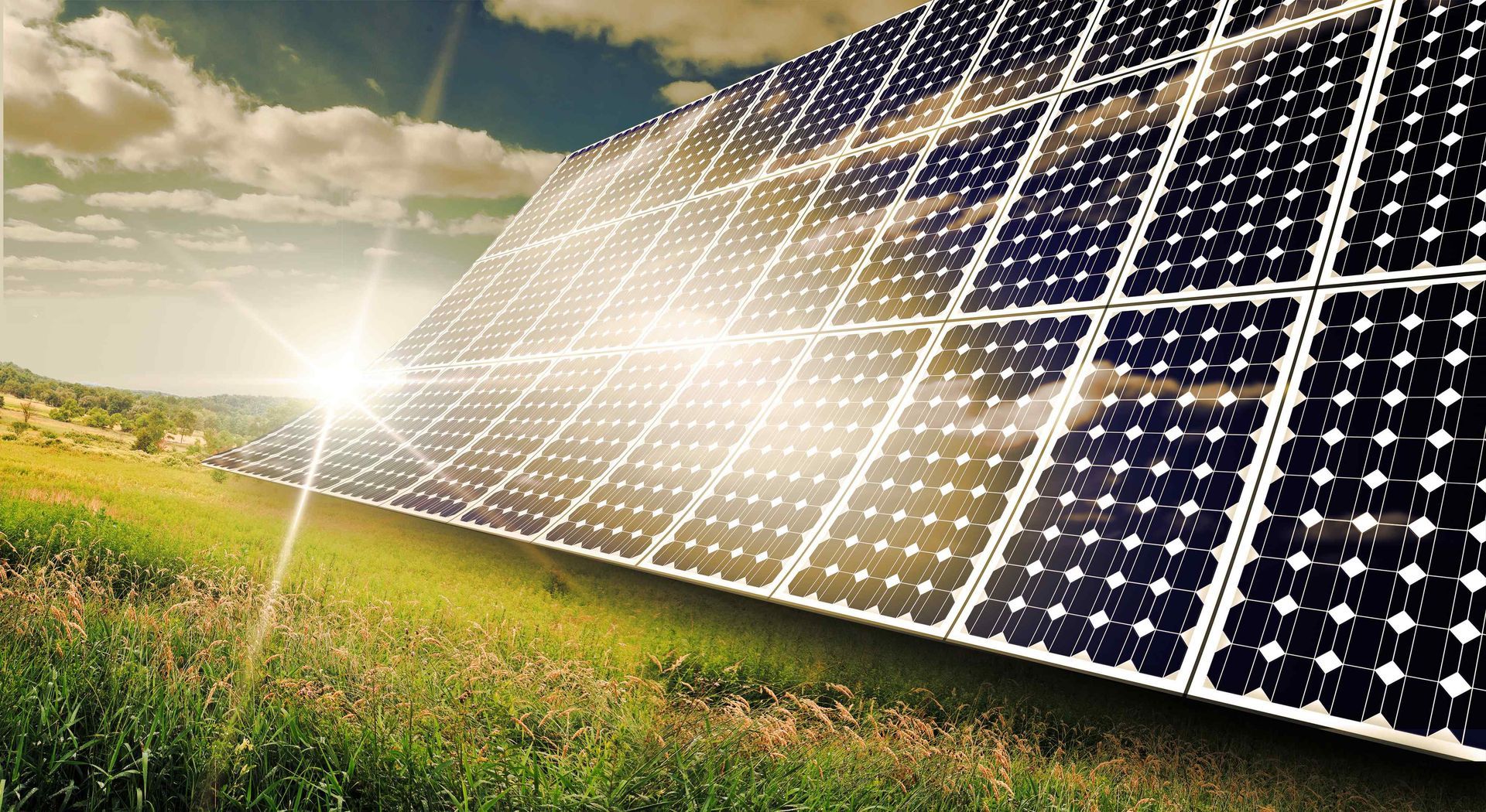 group of solar panels sitting at an angle in a grassy field to capture the shing sun