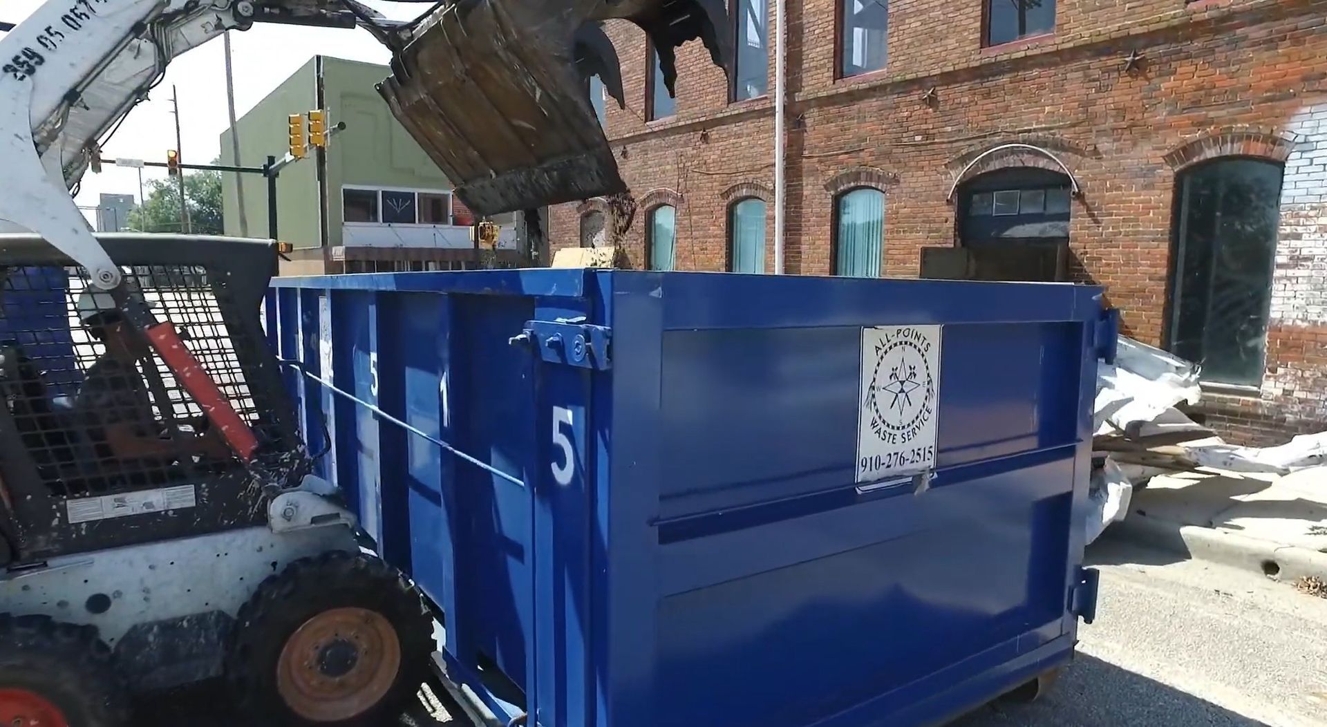 A blue dumpster with the number 5 on it