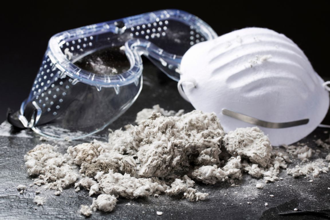 A pair of goggles and a mask are sitting on top of a pile of dust.