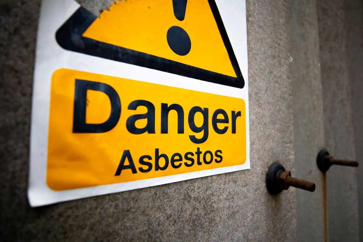 A sign on a wall that says danger asbestos