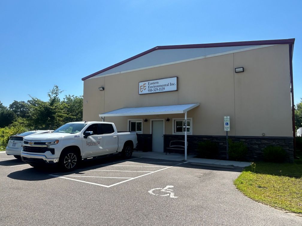 A white truck is parked in front of a building.