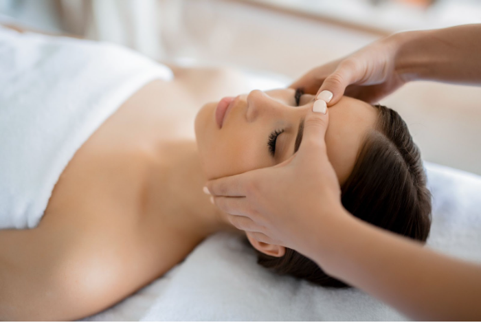 A woman is getting a head massage at a spa.