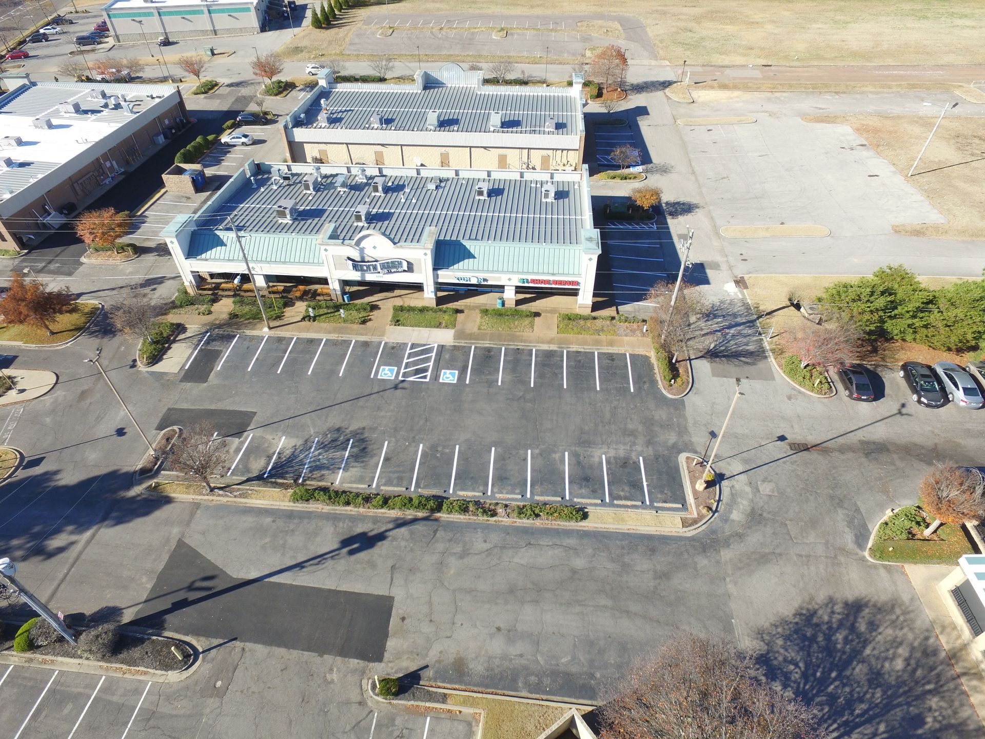 A black and white photo of a man standing in front of a dumpster.