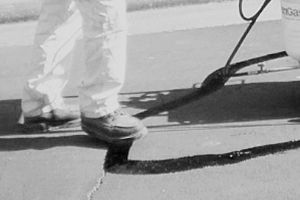 A black and white photo of a person standing on a skateboard.