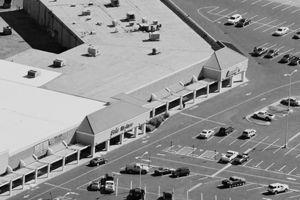 An aerial view of a parking lot with a store in the background.