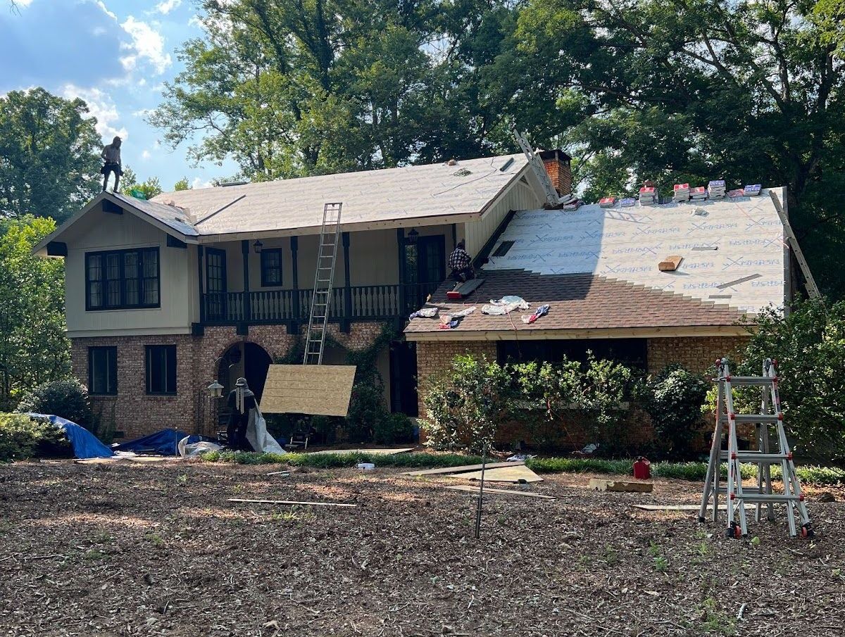 A large house is being remodeled with a roof being installed.