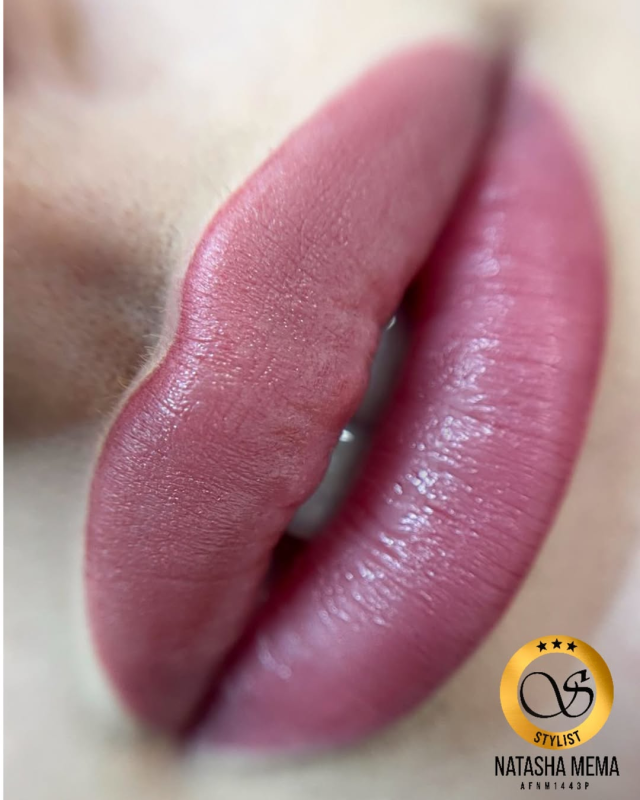 Un primo piano delle labbra di una donna con rossetto rosa