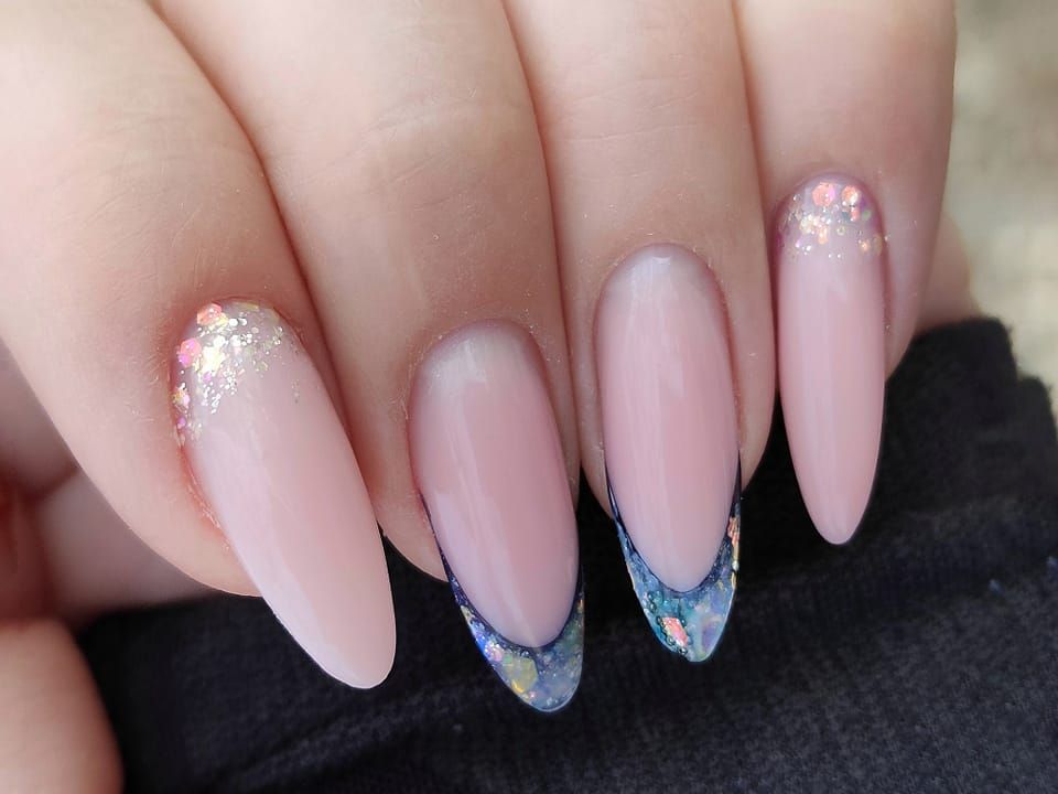Un primo piano delle unghie di una persona con una french manicure.