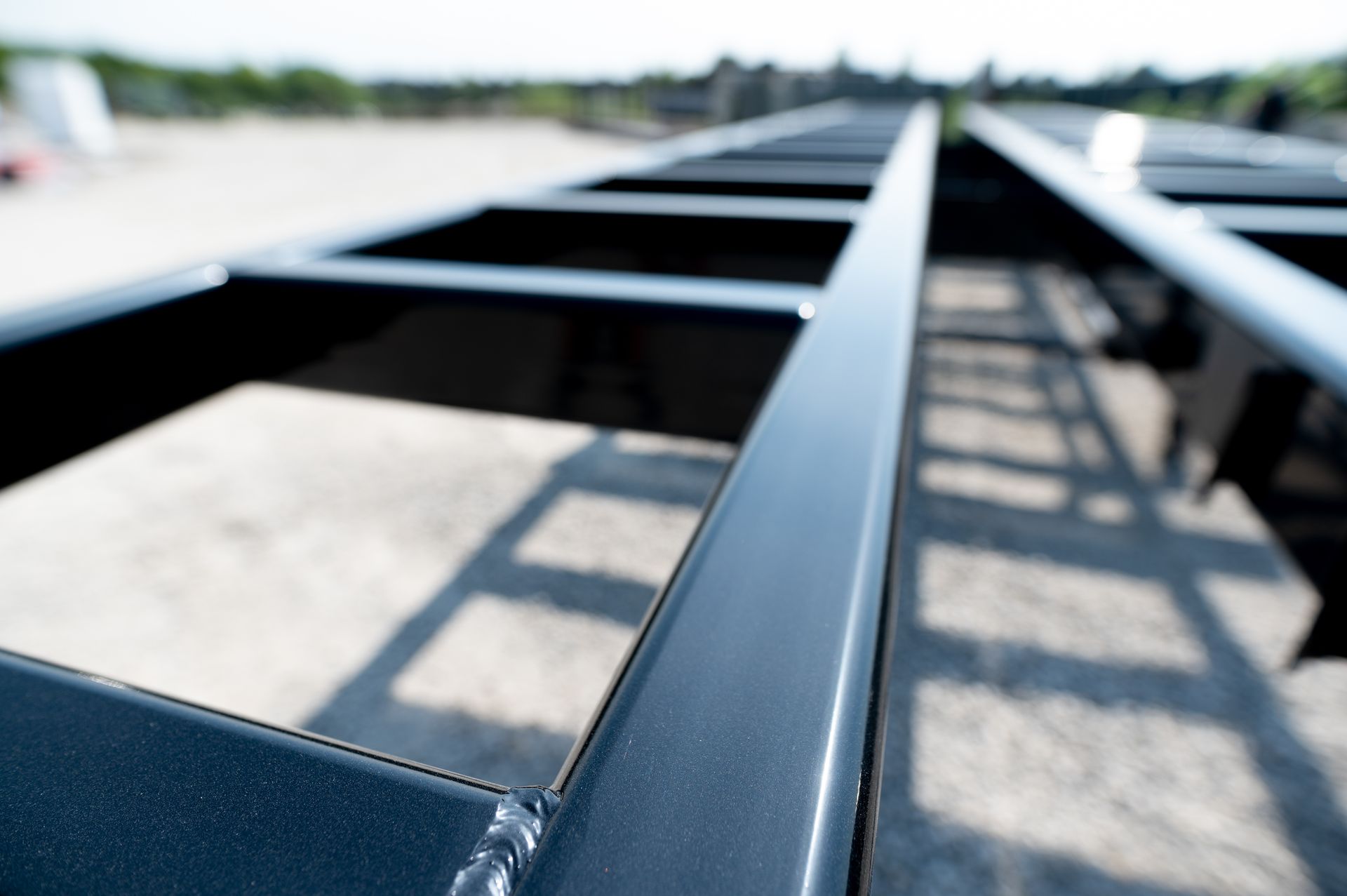 Black metal rectangular frame on concrete ground, close-up perspective.