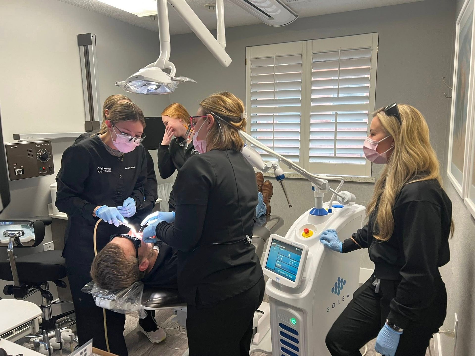 Baby sticking out tongue, holding onto a stroller bar; smiling.