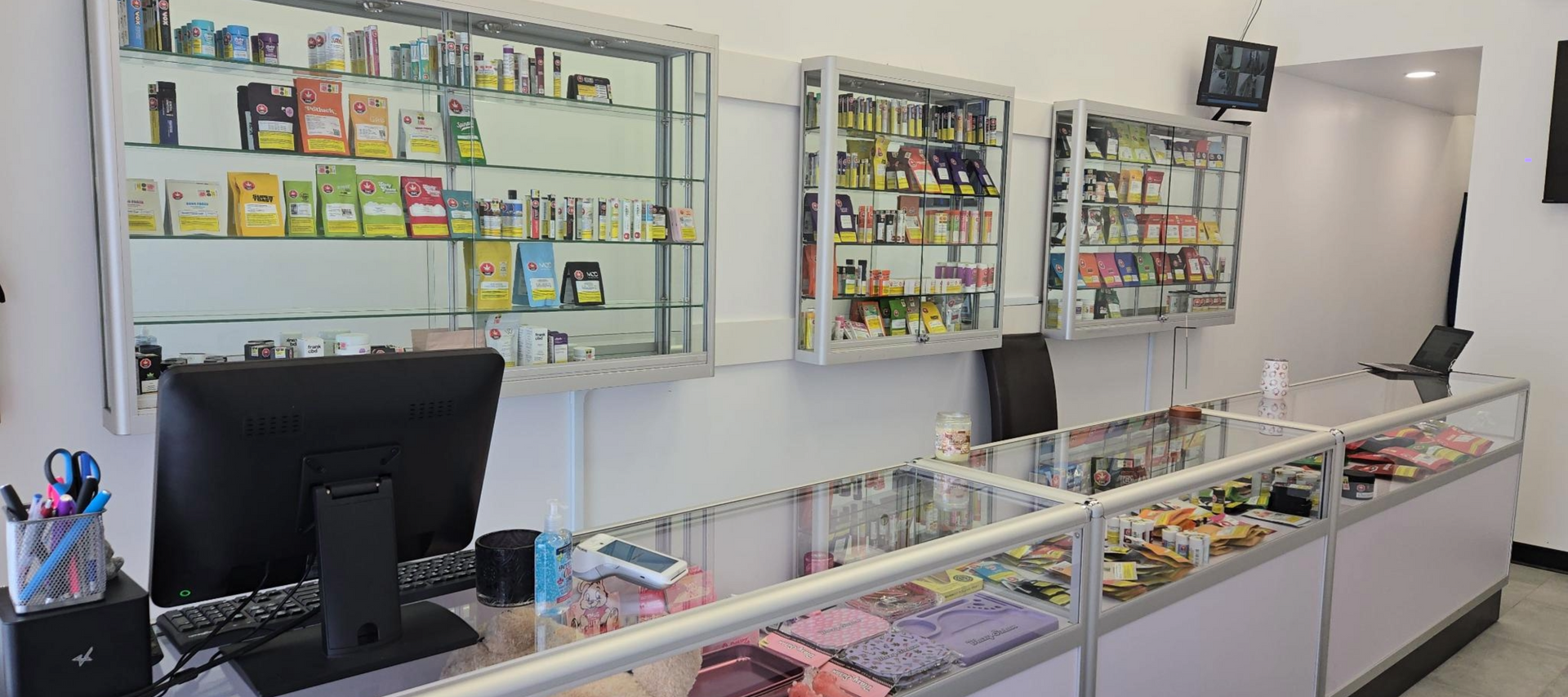 Interior of a store selling cannabis product. Display cases with merchandise and a counter with a computer.