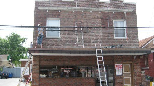 Image Of Working On Building — St. Louis, MO — Mirelli Tuckpointing LLC