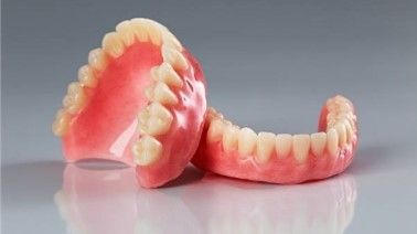 A pair of dentures sitting on top of each other on a table.
