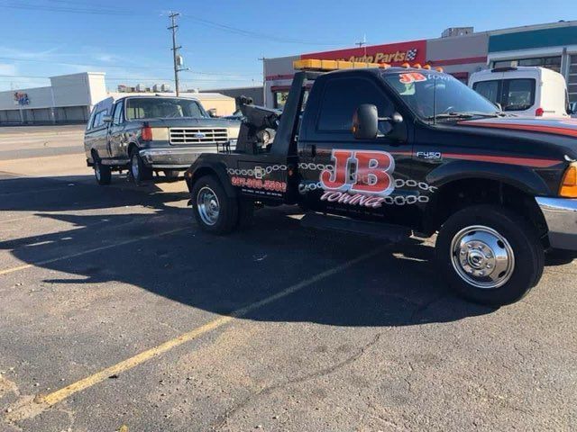 A jb tow truck is parked in a parking lot