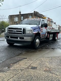 A ford tow truck is parked on the side of the road