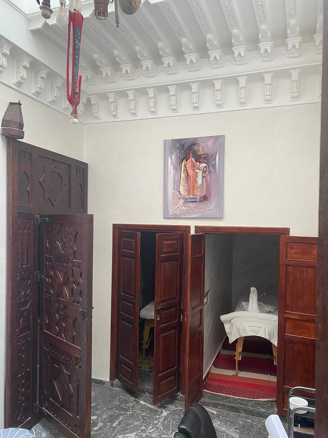 A room with wooden doors and a painting on the wall