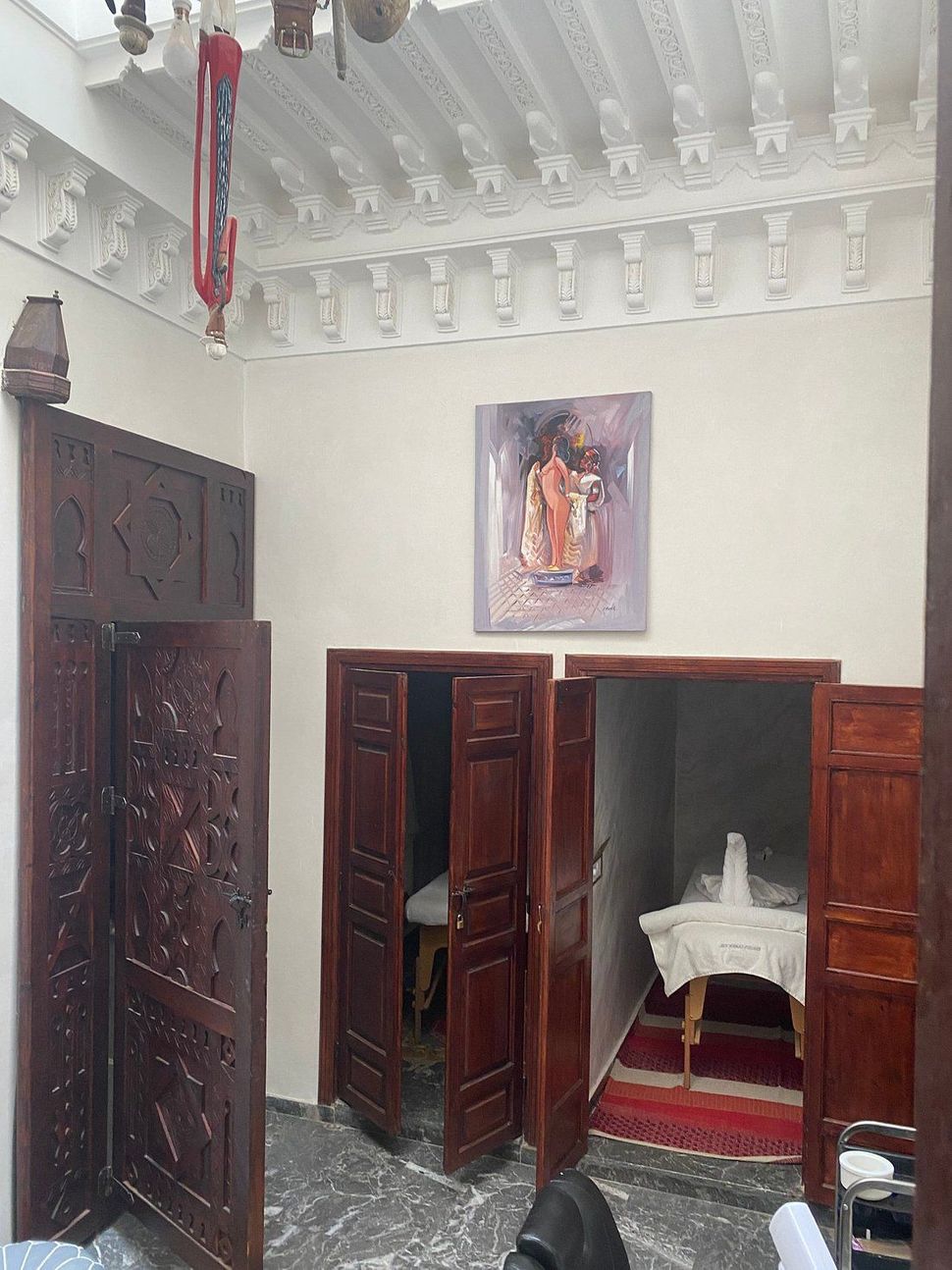 A room with wooden doors and a painting on the wall