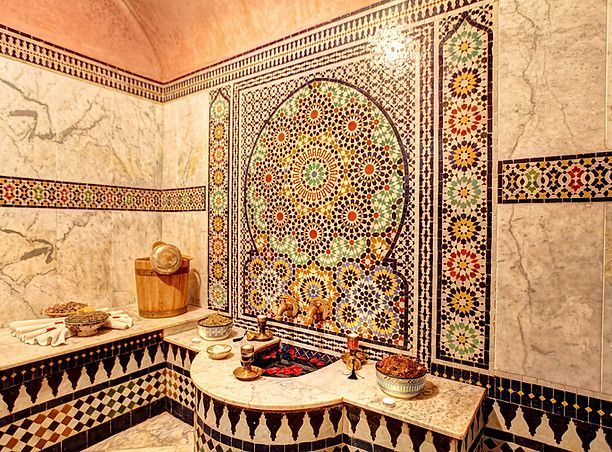 A bathroom with a colorful mosaic on the wall.