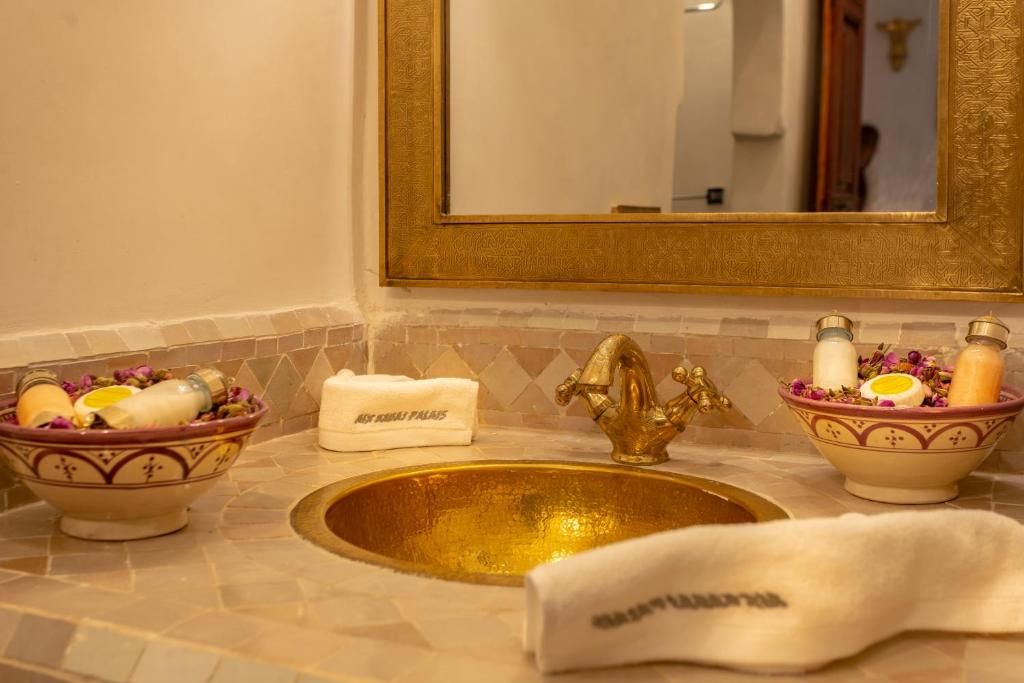 A bathroom with a sink , mirror and bowls of soap.