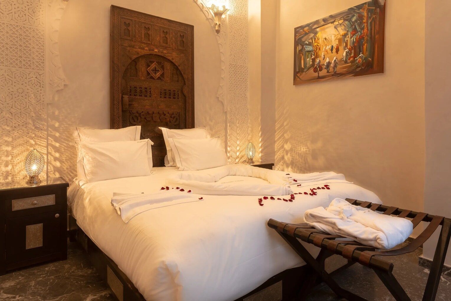 A bedroom with a bed , nightstand , and a painting on the wall.