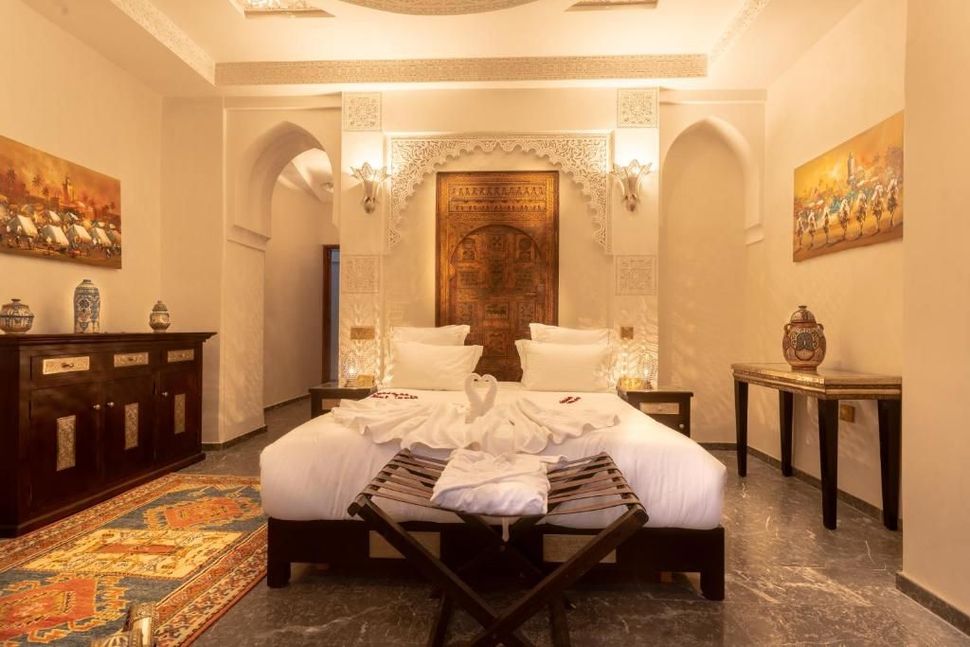 A bedroom with two beds , a rug and a dresser.