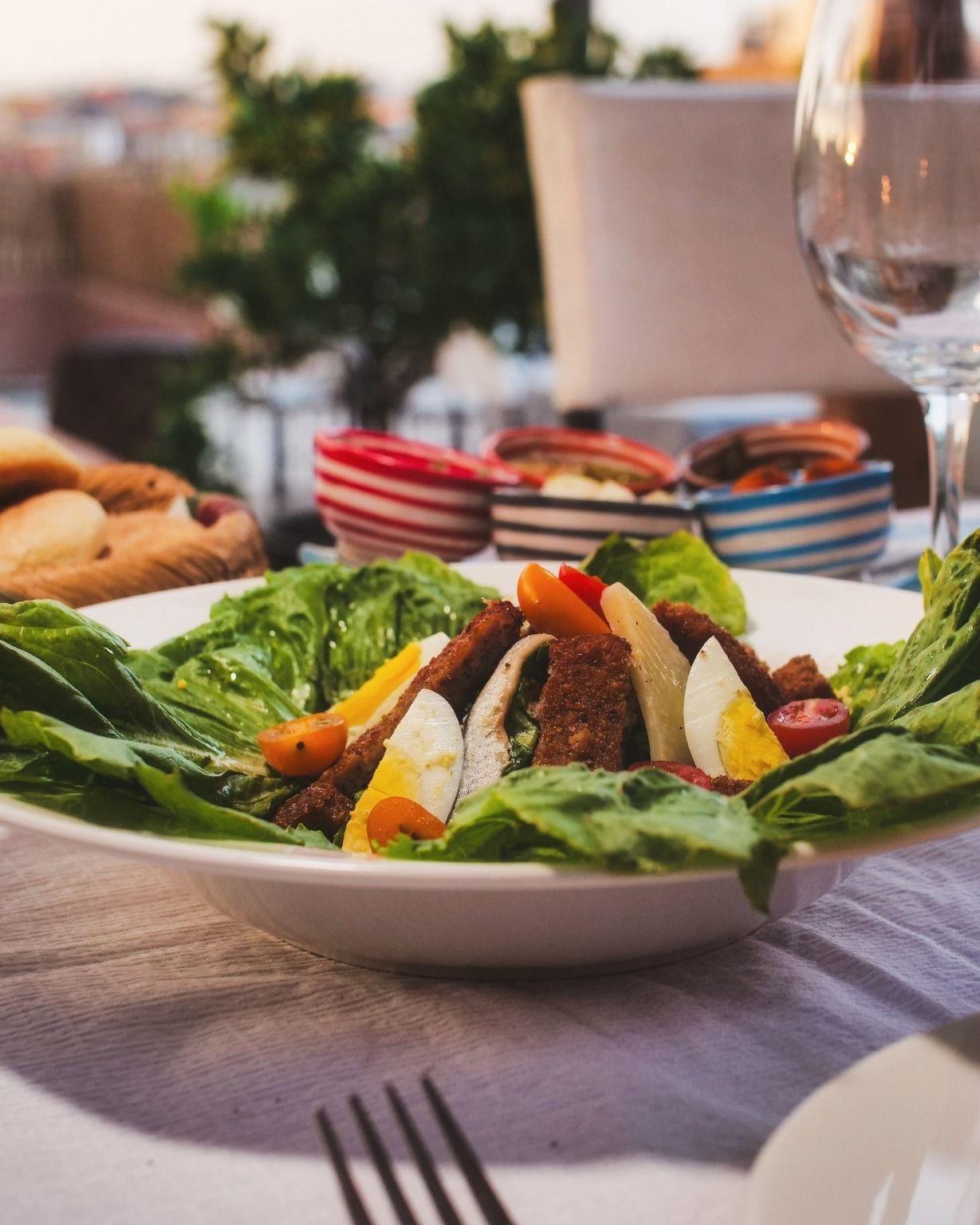 A plate of food with lettuce eggs and meat on a table